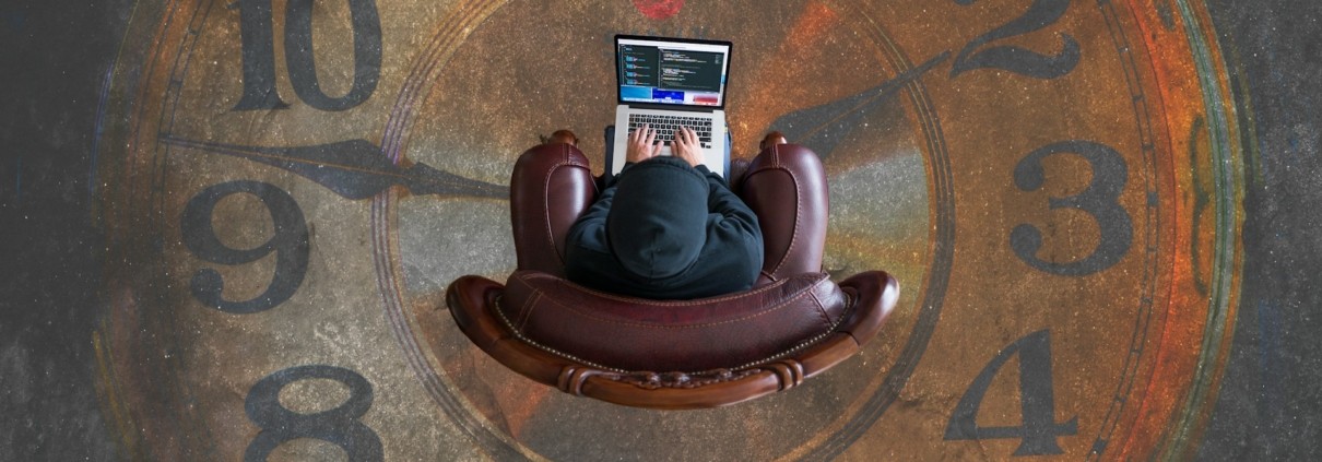 Man in het midden van een klok op zijn laptop